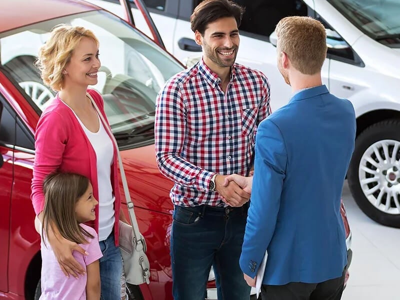 Family shaking hands with sales representative